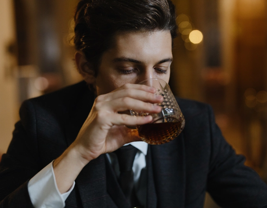 man swirling whiskey in mouth while whiskey tasting