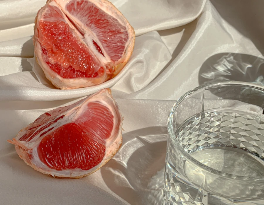 grapefruit on table next to glass with tonic water