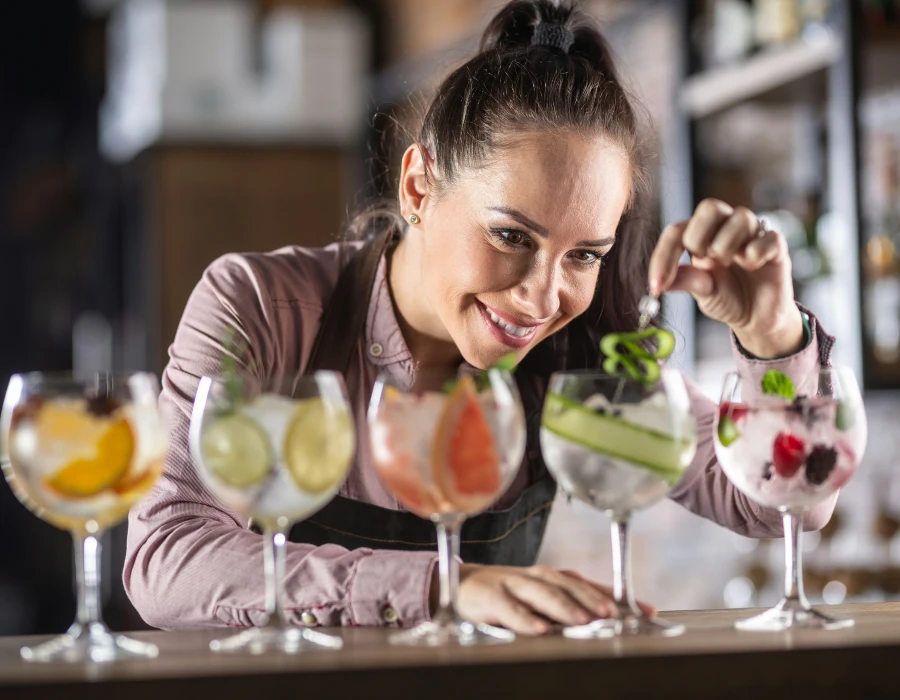 bar lady garnishing different gins