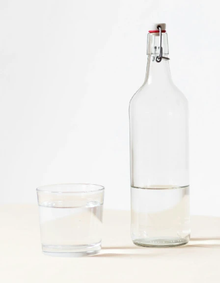 water glass next to bottle.webp