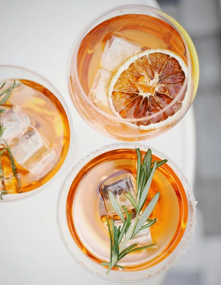3 gin cocktails with orange garnish