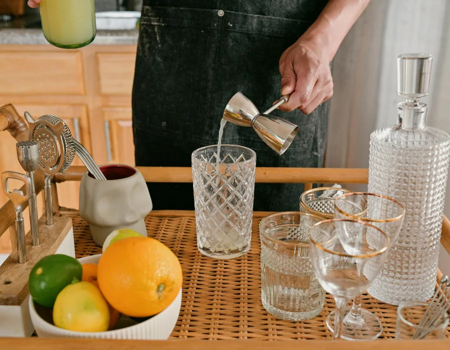 man pouring from thimble standing behind drinks trolley
