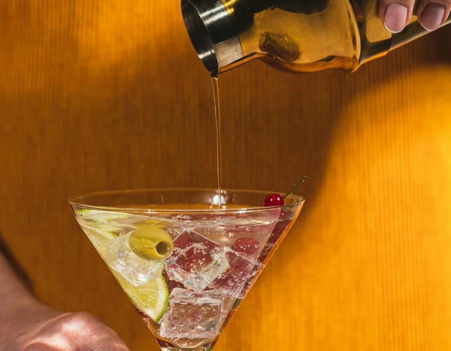 woman pouring martini into glass