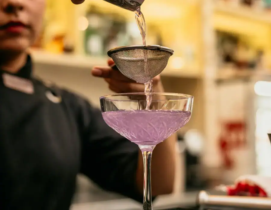 bartender straining cocktail